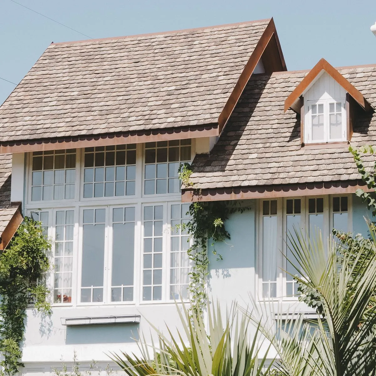 A house with a shingled roof and large windows