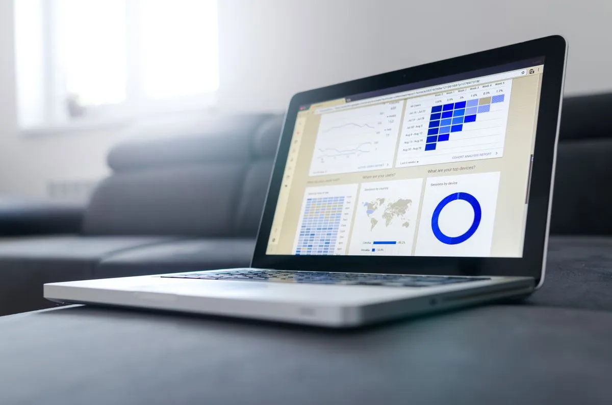 A laptop displaying business analytics charts and a software dashboard